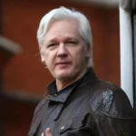 Julian Assange ao centro saindo de sua casa